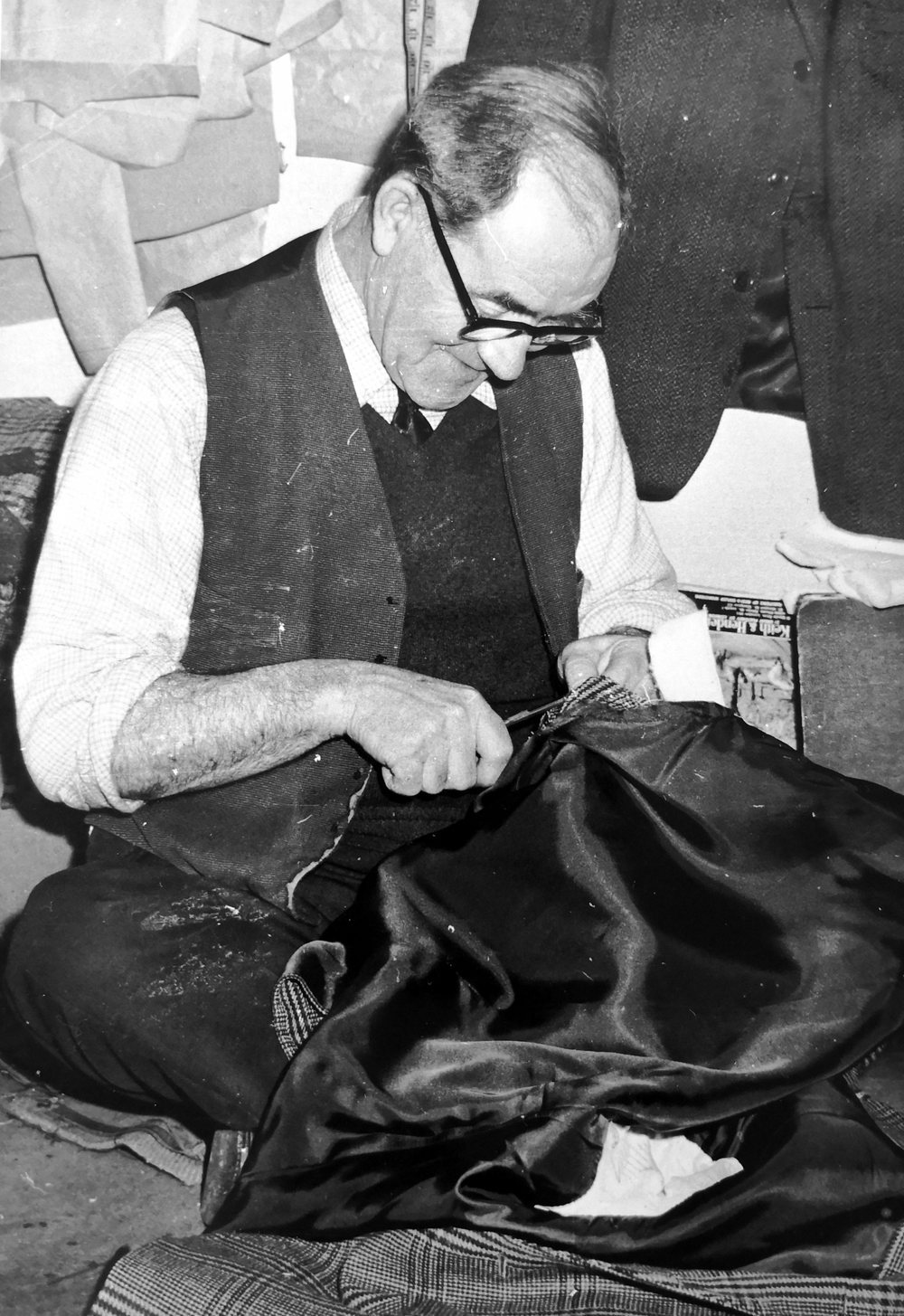 After 50 years of service with the firm, tailor John Trainor retired. When he started as an apprentice in 1921 at 5 shillings (now 25p) a week, he was paid an extra half a crown (the equivalent of 12.5p) a week for coming in early to light the stove to heat the pressing irons. The stove can still be seen in the tailoring shop.
