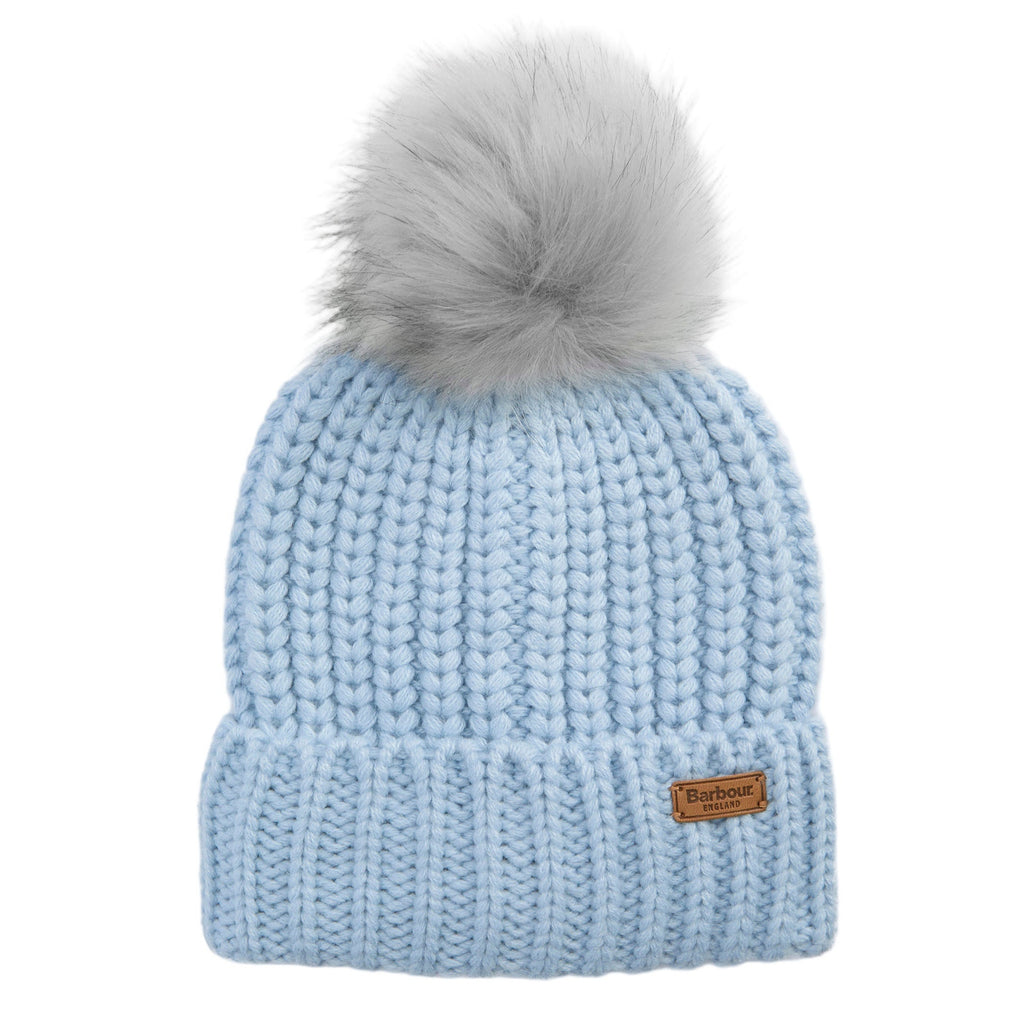 Light blue knit beanie with a faux fur pom-pom on a light gray background